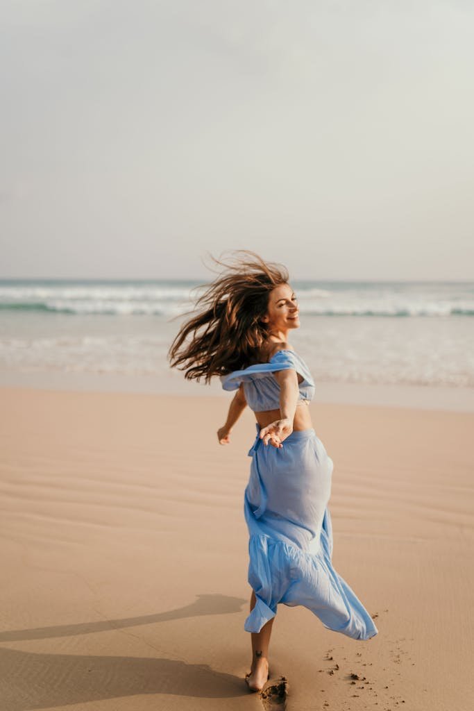 Back View of Woman in Blue Dress on Beach