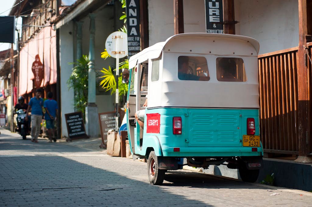 A vibrant tuk-tuk parked on a sunny street in Galle, Sri Lanka, showcasing local culture.