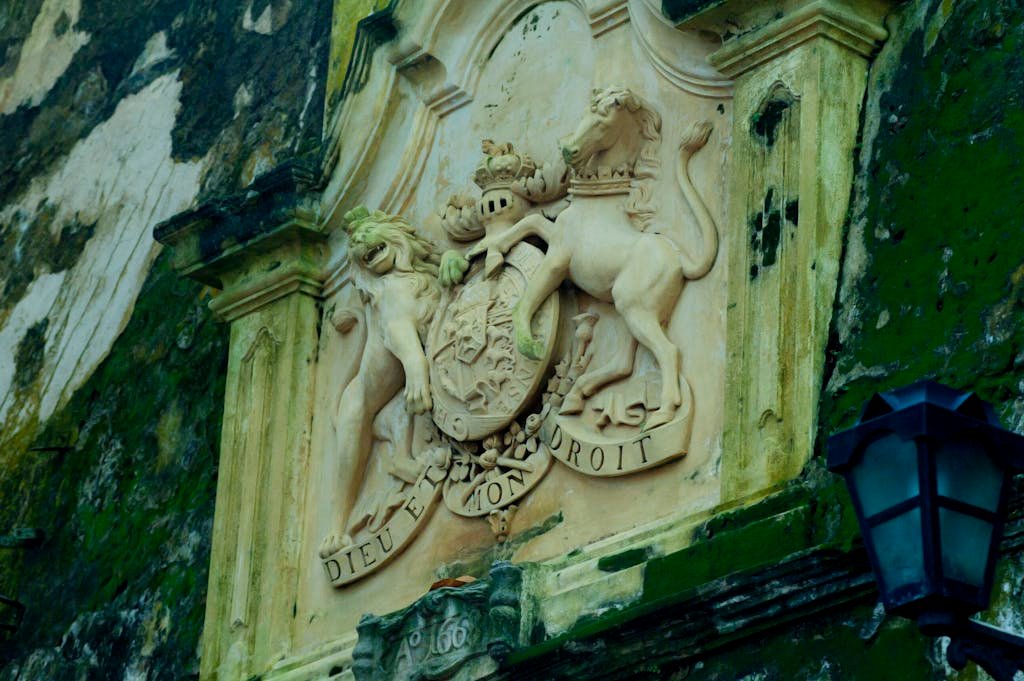 Intricate stone sculpture of a royal emblem on a historic building in Galle Fort, Sri Lanka.Galle Day Trip: Unveiling the Timeless Charm of Sri Lanka's Coastal Jewel..